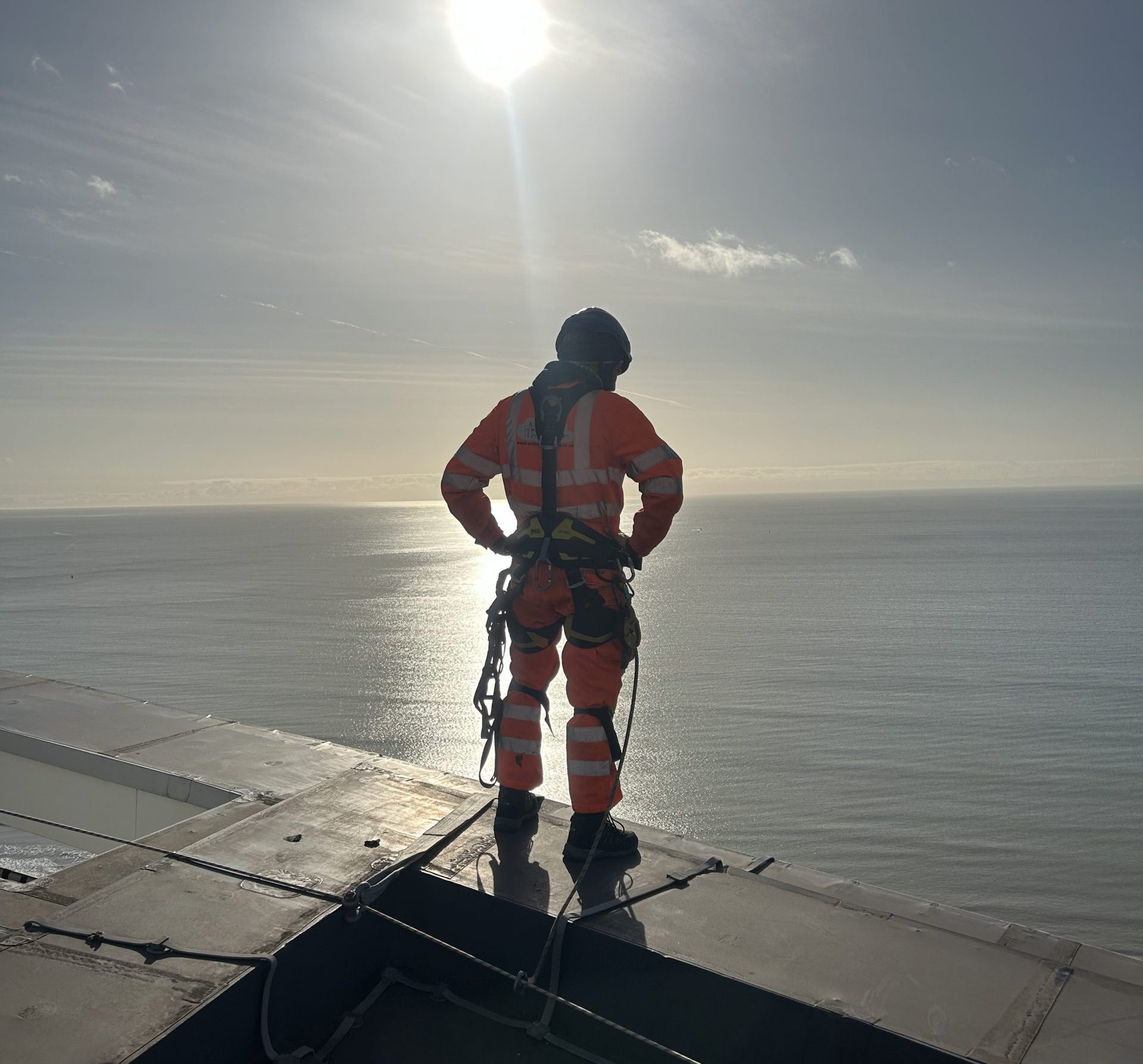 IRATA certified rope access technician overlooking the sea