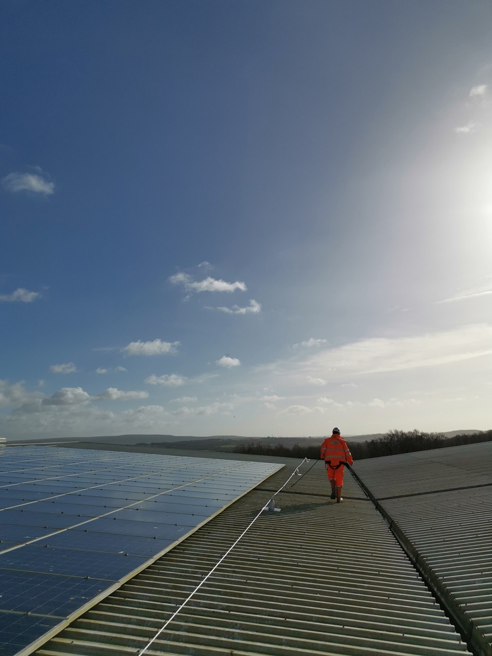 Rope access technician performing facade inspection on glass roof — Brope